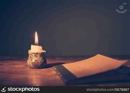 A small notebook on a table next to a candle