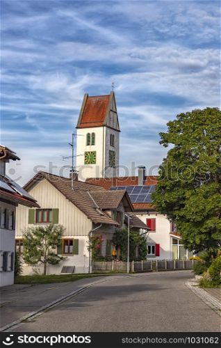 a small quiet street with houses and a clock tower in Leutkirch, Germany