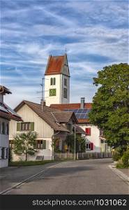 a small quiet street with houses and a clock tower in Leutkirch, Germany