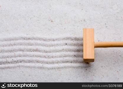 A small rake, creating a design in a zen garden