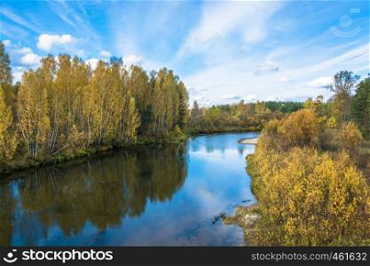 A small river in the decoration of the yellow autumn trees October day.