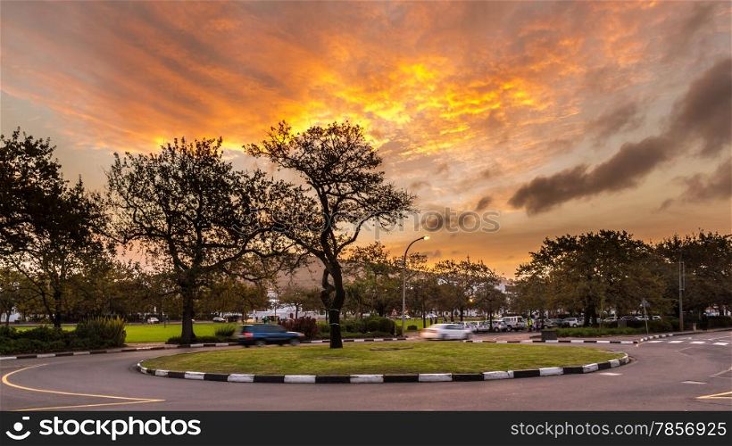 A small roundabout overlooking the mountains in the city of Stellenbosch, South Africa during a warm glowing sunset