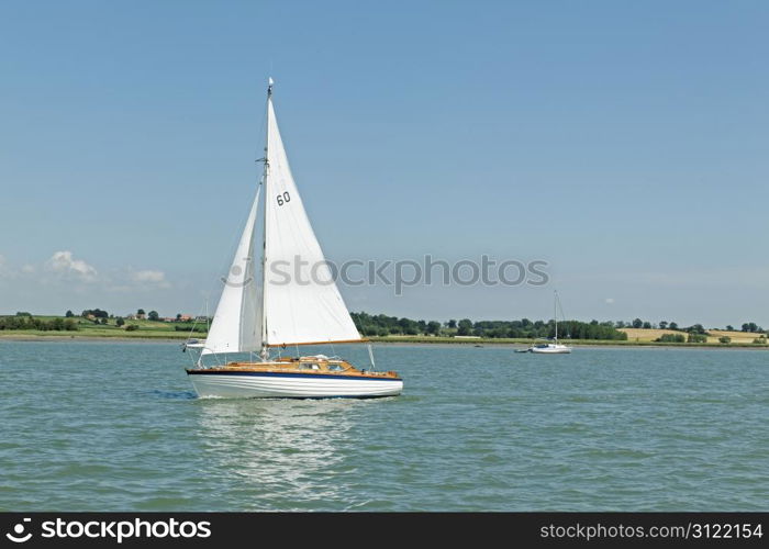 A small sailing yacht on a river - numbers on the sail are NOT a logo