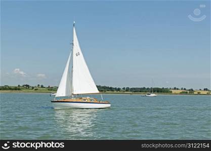 A small sailing yacht on a river - numbers on the sail are NOT a logo