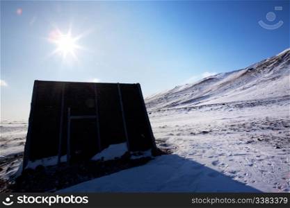 A small shelter on a barren northern landscape