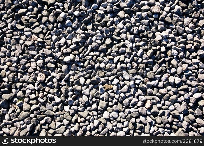 A small stone background texture of smooth stones near the ocean.