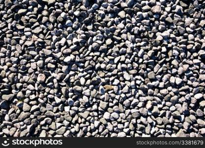 A small stone background texture of smooth stones near the ocean.