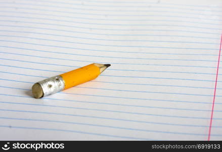 a small stub of a pencil lying on a school notebook in line