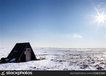 A small winter shelter on the frozen coast of Spitsbergen Island, Svalbard, Norway