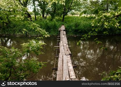 A small wooden bridge over a mild stream in a green park. A small wooden bridge over a mild stream in a green park.