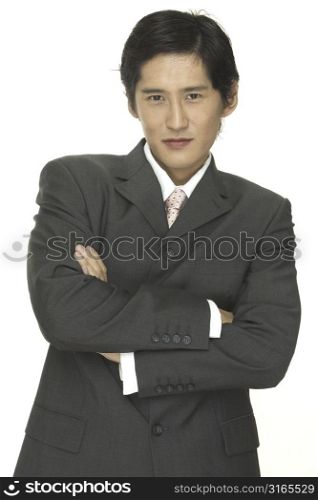 A smart asian businessman with his arms folded across his chest