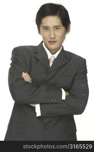 A smart asian businessman with his arms folded across his chest