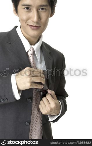 a smiling asian businessman in a grey suit takes his wallet from his jacket