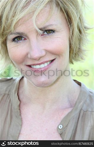 A smiling blond woman looking at us.