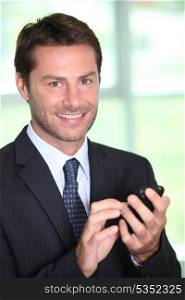 A smiling businessman about to make a phone call.
