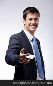 A smiling businessman holds out a credit card