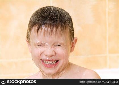 A smiling child washing in the shower