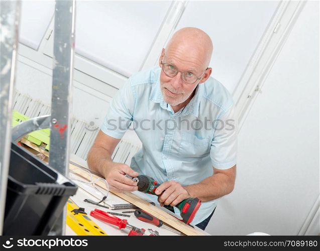 a smiling mature man DIY at home