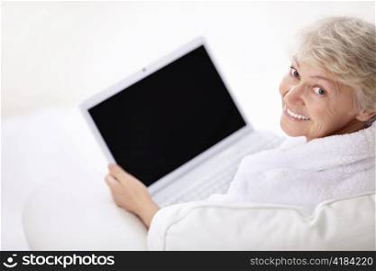 A smiling older woman with a laptop