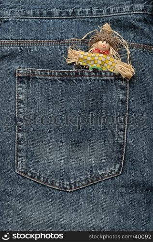 A smiling scare crow figure sticking out of the back of a denim jean