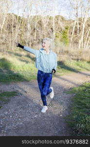 A smiling sporty woman watching and pointing far away