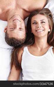 A smiling young couple in bed