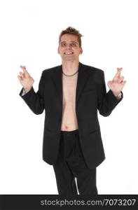 A smiling young man in a dark jacket but without a shirt standingwith his fingers crossed hoping for luck, isolated for white background