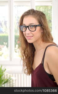 a smiling young woman with black glasses