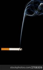 a smoking cigarette. a smoking cigarette in front of black background
