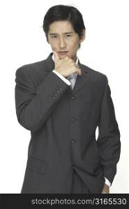 A smooth and sophisticated asian businessman in a grey suit