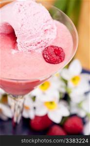 A smoothie with ice cream and raspberries