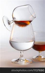 A snifter of brandy being warmed above a glass of hot water. The large surface area of the liquid helps evaporate it, the narrow top traps the aroma . The rounded bottom allows the glass to be cupped in the hand, warming the liquor.