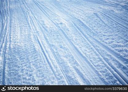A snow texture of snowmobile tracks converging into the distance