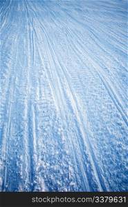 A snow texture of snowmobile tracks converging into the distance