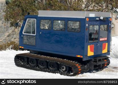 A snow transport vehicle parked outside a chalet at a resort in the Australian Alps