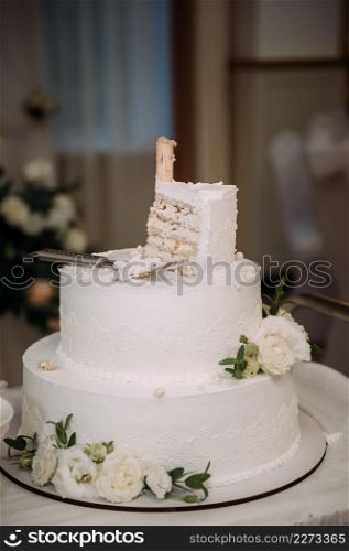 A snow-white cake with four tiers.. A four-tiered cake decorated with green leaves 3852.