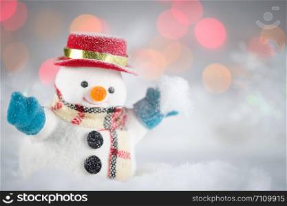 A snowman playing snow and decorations on bokeh background, with copy space for season greeting. Merry Christmas or Happy New Year, AF point selection.