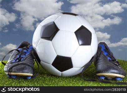A Soccer ball between two soccer shoes