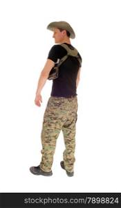 A soldier in camouflage pants and black t-shirt and hat standing relaxedfrom the back, isolated for white background.