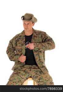 A soldier in camouflage uniform and hat pulling his hand gunout of the holster, isolated on white background.