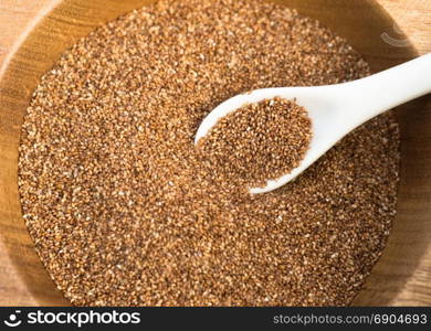 A spoon white sits in a bowl of Red Wheat