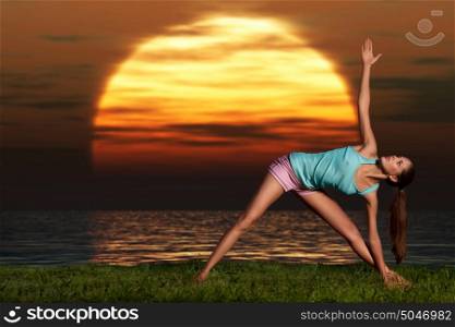 A sportive beautiful woman training yoga on the beach at dawn.