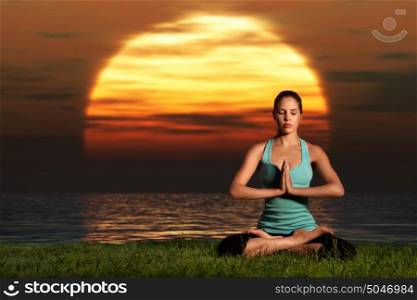 A sportive beautiful woman training yoga on the beach at dawn.