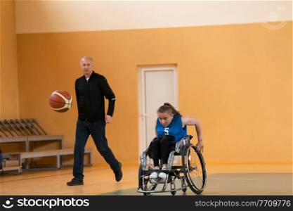 a sports basketball coach explains to a disabled woman in a wheelchair which position to play during a game. High quality photo. a sports basketball coach explains to a disabled woman in a wheelchair which position to play during a game