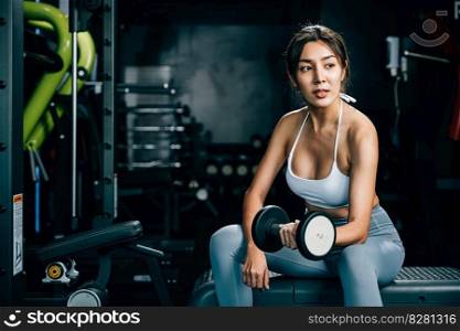 A sporty female engaging in weightlifting training at the gym, using dumbbells to exercise her arms and build up her strength and endurance, fitness GYM dark background