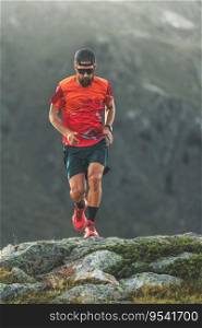 A sporty man with a beard trains by running in the mountains