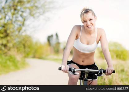 A sporty woman riding a bicycle outdoor