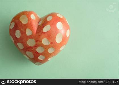 A spotted heart isolated on a green background