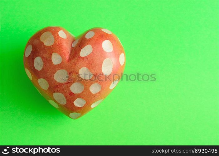 A spotted heart isolated on a green background