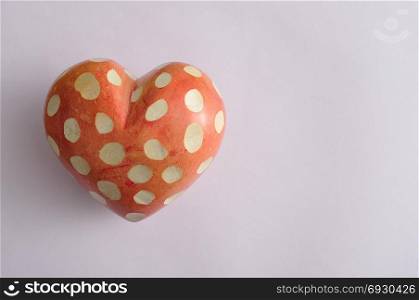 A spotted heart isolated on a purple background